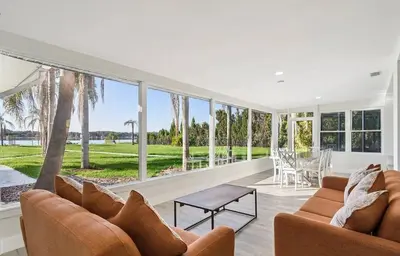 a living room with two couches and a table at Lakefront Luxury w Private Dock Sunrises in Orlando