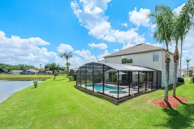 a home with a swimming pool and a house at Luxury 7BR w Pool Lake View at Berkley in Kissimmee