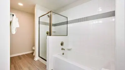 a white bathroom with a shower and a tub at Vista Cay Resort Near Parks Convention Center in Orlando