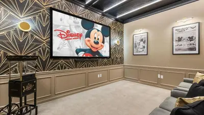 a movie room with a screen in the wall at Upstay Great 3BR Condo w Scenic Views & Patio in Orlando