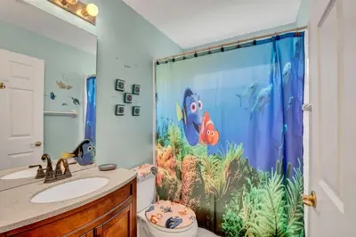 a bathroom with a fish shower curtain and a sink at Minutes from Disney Themed 2 Bd Villa with Private Pool home in Orlando