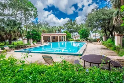 a swimming pool with a table and chairs at Minutes from Disney Themed 2 Bd Villa with Private Pool home in Orlando