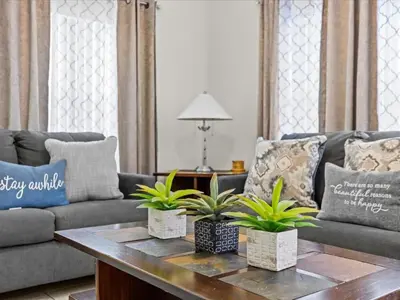 a living room with a couch and a table with plants at 4bd Villa Near Epic Universe and Disney with private Pool townhouse in Kissimmee