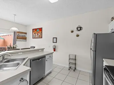 a kitchen with a sink and a refrigerator at 4bd Villa Near Epic Universe and Disney with private Pool townhouse in Kissimmee