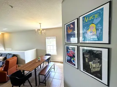 a living room with a table and pictures on the wall at Very Near Disney 3 Bd Condo Walmart 1 min away townhouse in Orlando