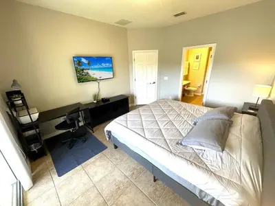 a bedroom with a bed and a desk with a computer at Very Near Disney 3 Bd Condo Walmart 1 min away townhouse in Orlando