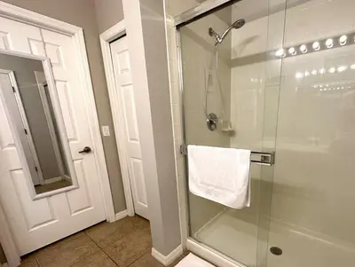 a bathroom with a glass shower with a white towel at Very Near Disney 3 Bd Condo Walmart 1 min away townhouse in Orlando