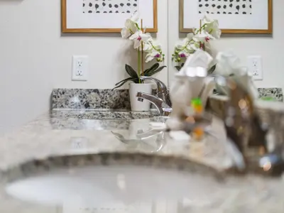 a bathroom counter with a sink and flowers on it at Elegant Townhome at West Lucaya in Kissimmee