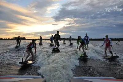 a group of people on surfboards in the water at Charming Lakefront Cottage Near Disney in Orlando