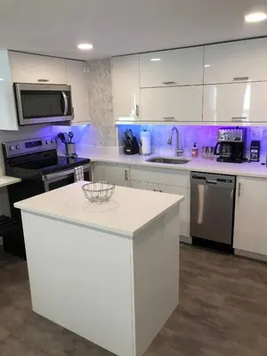 a kitchen with white cabinets and a white counter top at Charming Lakefront Cottage Near Disney in Orlando