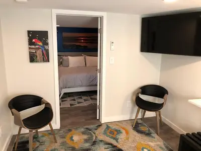 two chairs in a room with a bed and a mirror at Charming Lakefront Cottage Near Disney in Orlando