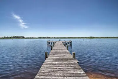 a wooden dock in the middle of a body of water at Charming Lakefront Apt Near Disney in Orlando