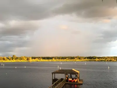 a boat on the water under a cloudy sky at Charming Lakefront Apt Near Disney in Orlando