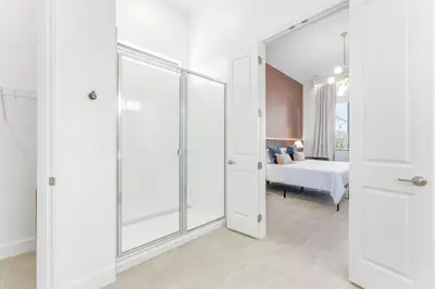 a bathroom with a shower and a bed in a room at Paradiso’s Luxurious New Home w 15 Ensuites in Orlando