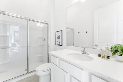 a white bathroom with a sink and a shower at Paradiso’s Luxurious New Home w 15 Ensuites in Orlando