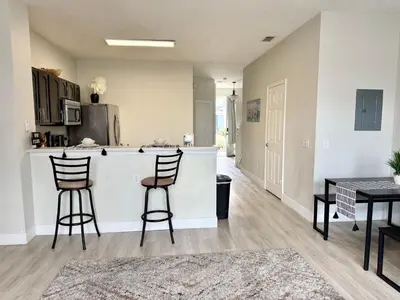 a kitchen with a counter and two bar stools at Affordable Suite Near Disney World, Universal Studios & SeaWorld in Orlando