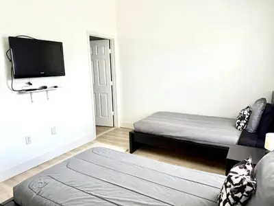 a room with two beds and a flat screen tv at Affordable Suite Near Disney World, Universal Studios & SeaWorld in Orlando