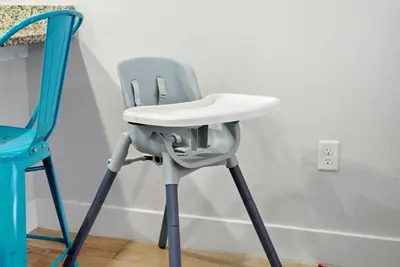 a blue and white high chair next to a lightswitch at Casita Coco - Private Pool - Foosball - BBQ in Kissimmee