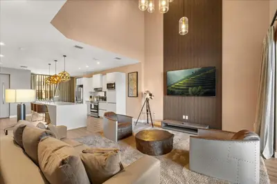a living room with a couch and a table and a kitchen at 5565Torino in Kissimmee