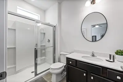 a bathroom with a toilet and a sink and a mirror at Resort-Style Living w Private Pool & Amenities in Kissimmee