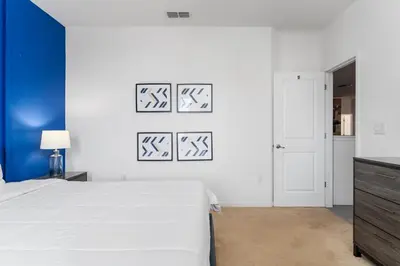 a bedroom with a white bed and a blue wall at 9 BR Family Home 8 Min to Disney SON104 in Kissimmee
