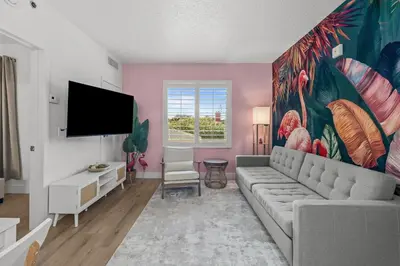a living room with a couch and a painting on the wall at Florida vibe suite near Epic Universe & Universal in Orlando