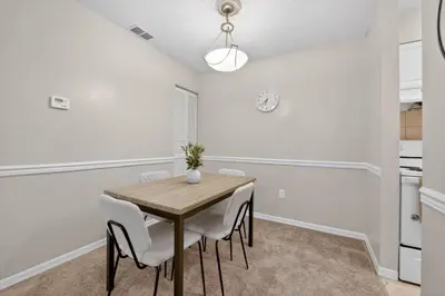 a dining room with a wooden table and white chairs at Modern 1BR with Premium Finishes in Orlando