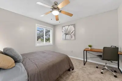 a bedroom with a bed with a ceiling fan and a desk at Modern 1BR with Premium Finishes in Orlando