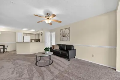 a living room with a couch and a ceiling fan at Modern 2BR Stay in Prime Location in Orlando