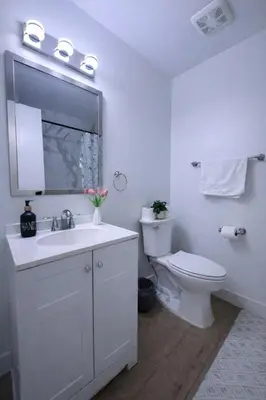 a white bathroom with a toilet and a sink at Family Retreat - 9 Min from Disney in Kissimmee