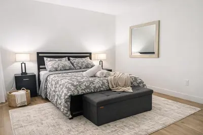 a bedroom with a bed with a ottoman and a mirror at Family Retreat - 9 Min from Disney in Kissimmee