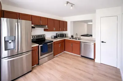 a kitchen with stainless steel appliances and wooden cabinets at Family Retreat - 9 Min from Disney in Kissimmee