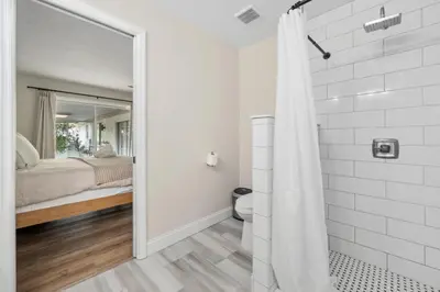 a white bathroom with a shower and a bed at Spacious home w screened patio & EV charger in Orlando