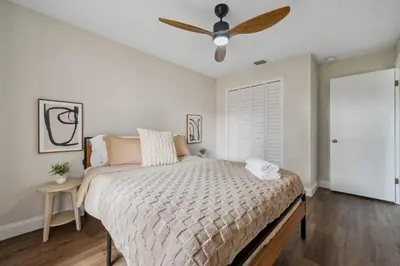 a bedroom with a bed and a ceiling fan at Spacious home w screened patio & EV charger in Orlando