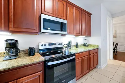 a kitchen with a stove and a microwave at Epic Universe Condo - Vista Cay - 2028 in Orlando