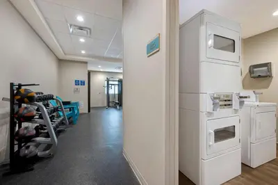 a room with a gym with a white refrigerator at Home2 Suites by Hilton Orlando International Drive South - Free Shuttle to Theme Parks in Orlando