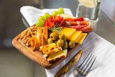 a plate of cheese and fruit on a cutting board at Magic Moment Resort & Kids Club, Dazzler Select by Wyndham in Kissimmee