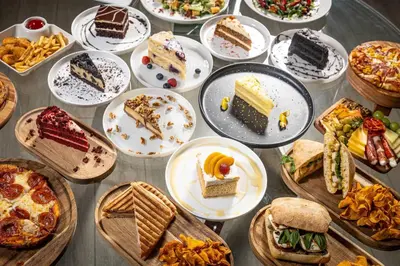 a table with many plates of food on it at Magic Moment Resort & Kids Club, Dazzler Select by Wyndham in Kissimmee