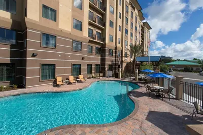 a swimming pool in front of a building at Staybridge Suites Orlando at SeaWorld by IHG - Free Breakfast & Shuttle to SeaWorld Parks in Orlando