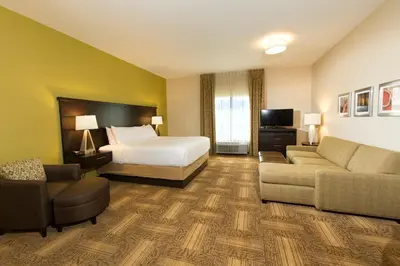 a hotel room with a bed and a couch at Staybridge Suites Orlando at SeaWorld by IHG - Free Breakfast & Shuttle to SeaWorld Parks in Orlando