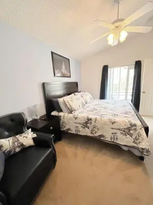 a bedroom with a bed and a ceiling fan at Clermont Vacation Homes by DWS Vacation in Orlando