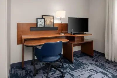 a desk with a computer monitor and a blue chair at Fairfield Inn & Suites by Marriott Orlando Kissimmee/Celebration in Orlando
