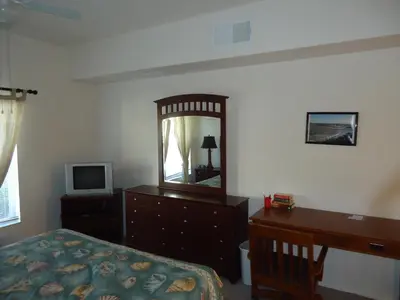 a bedroom with a bed and a dresser and a mirror at True Happiness, Housing Near Disney Word in Kissimmee