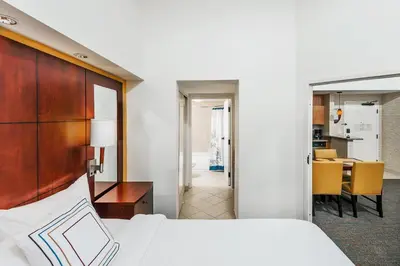a bedroom with a bed and a dining room at Residence Inn Orlando Airport in Orlando