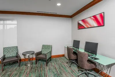 a waiting room with chairs and a desk with a computer at Residence Inn Orlando Airport in Orlando