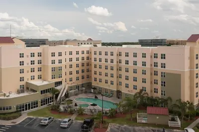 an aerial view of a large building with a pool at Residence Inn Orlando Airport in Orlando