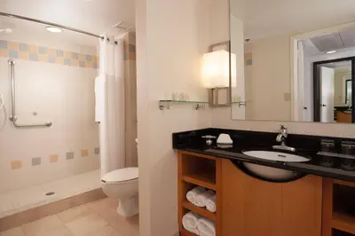 a bathroom with a sink and a toilet and a mirror at Renaissance Orlando Airport Hotel in Orlando