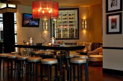 a bar with stools and a table in a restaurant at Renaissance Orlando Airport Hotel in Orlando