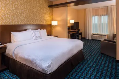 a hotel room with a large bed and a desk at Fairfield Inn & Suites by Marriott Orlando East/UCF Area in Orlando