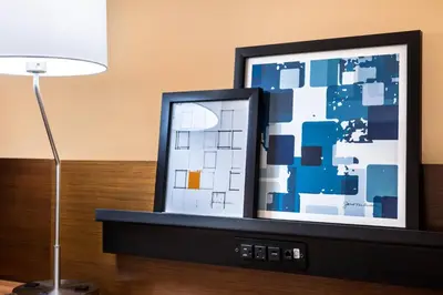 a television with a picture on it next to a lamp at Fairfield Inn & Suites by Marriott Orlando East/UCF Area in Orlando